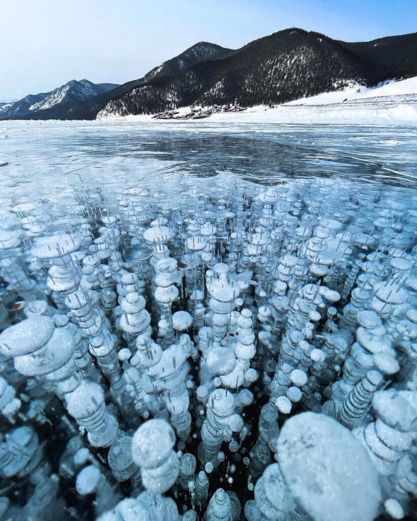 Frozen bubbles under Lake Baikal, Russia. This phenomenon occurs when decaying plants from the bottom of the lake release methane gas, creating bubbles that become trapped within the ice as the lake